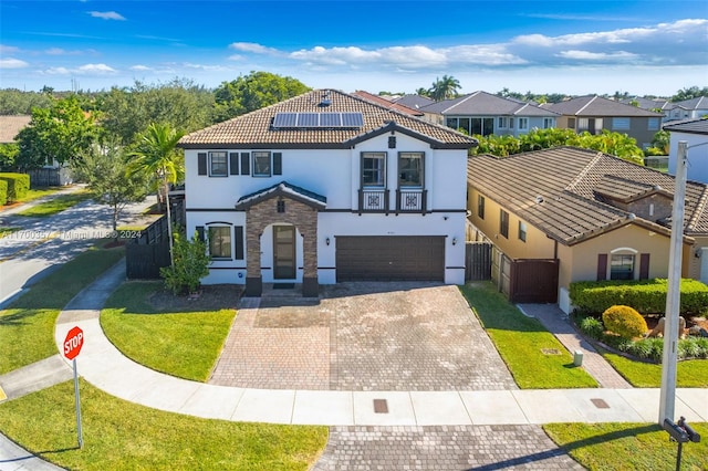 mediterranean / spanish house with solar panels, a garage, and a front yard