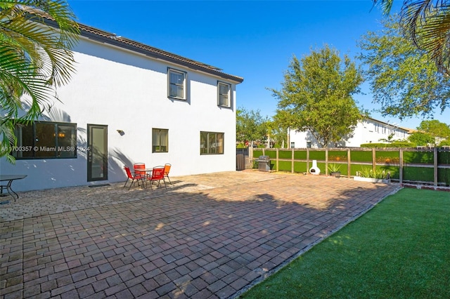 rear view of property with a patio and a lawn