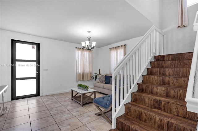 tiled foyer with a chandelier