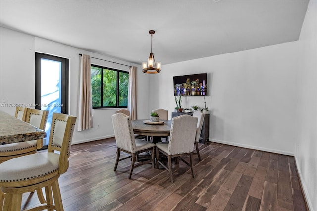 dining area with an inviting chandelier and dark wood-type flooring