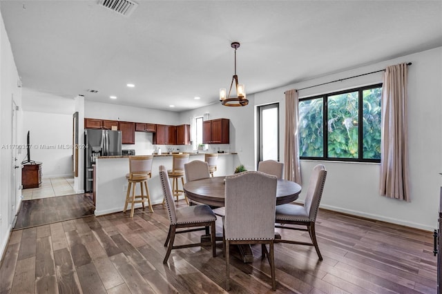 dining area featuring hardwood / wood-style flooring and an inviting chandelier