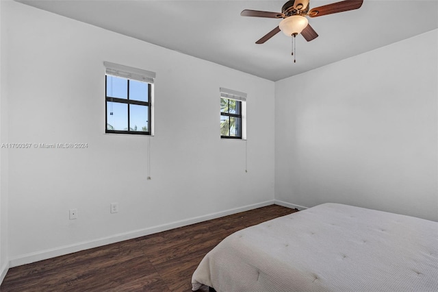 bedroom with dark hardwood / wood-style flooring and ceiling fan