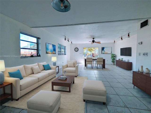 tiled living room featuring ceiling fan, plenty of natural light, and track lighting