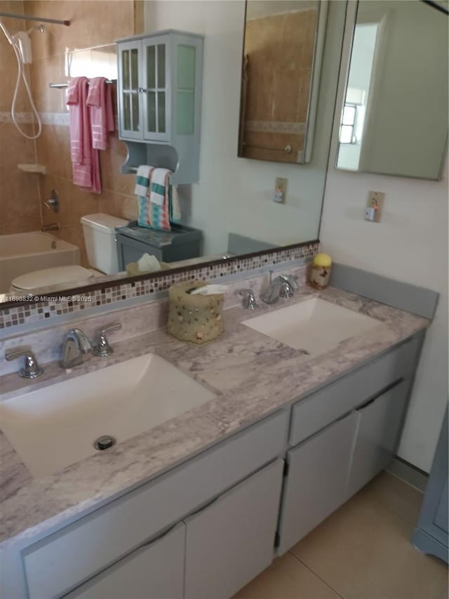 bathroom featuring tiled shower / bath combo, vanity, backsplash, and tile patterned floors