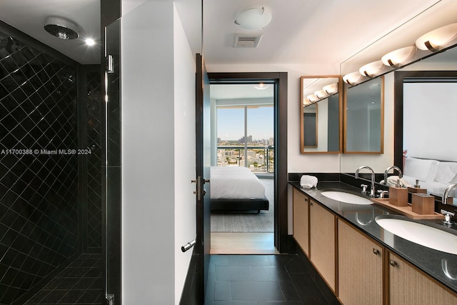 bathroom featuring tile patterned flooring, vanity, and tiled shower