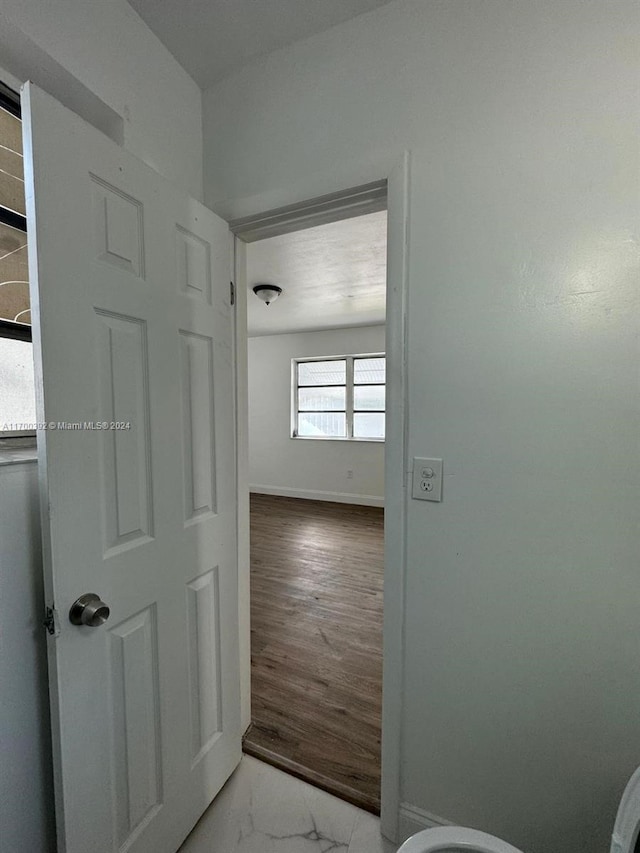 corridor with hardwood / wood-style flooring