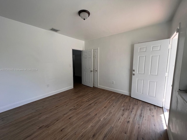 unfurnished bedroom with dark hardwood / wood-style flooring