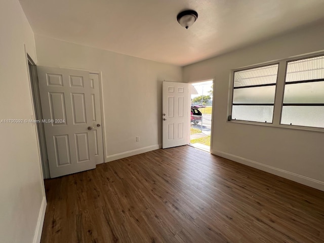 unfurnished room with dark hardwood / wood-style flooring