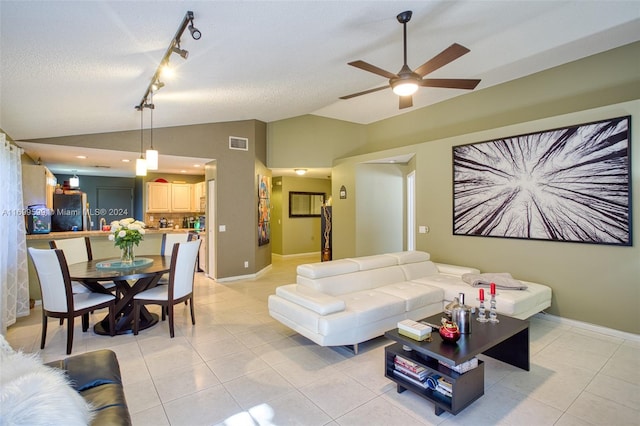 tiled living room featuring ceiling fan, a textured ceiling, high vaulted ceiling, and track lighting