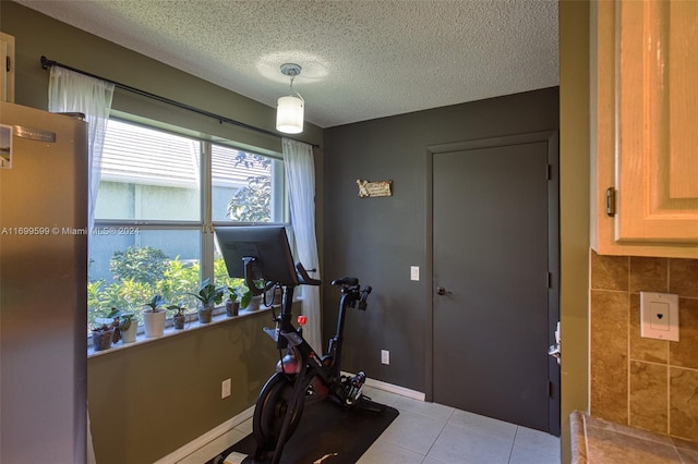 workout room featuring light tile patterned floors and a textured ceiling