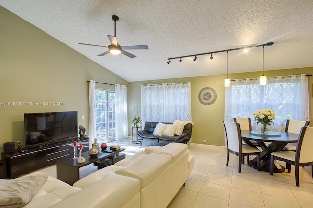 tiled living room with ceiling fan, lofted ceiling, and a textured ceiling