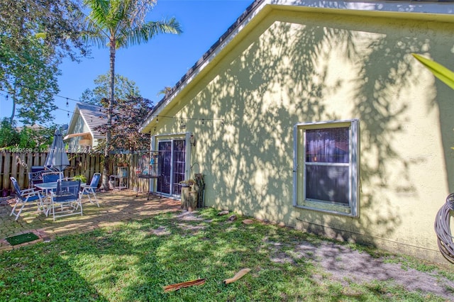 rear view of property featuring a yard and a patio area