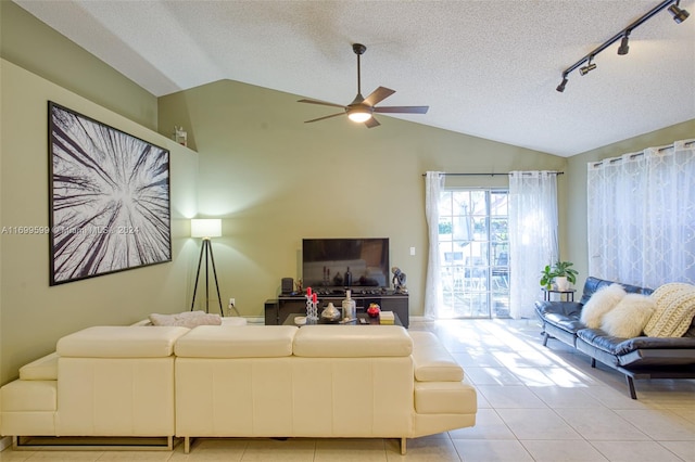 living room with ceiling fan, light tile patterned floors, and vaulted ceiling