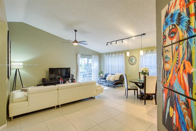 living room with light tile patterned floors, a textured ceiling, ceiling fan, and lofted ceiling