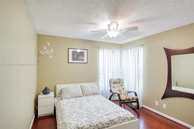 bedroom featuring dark hardwood / wood-style floors, ceiling fan, and a textured ceiling