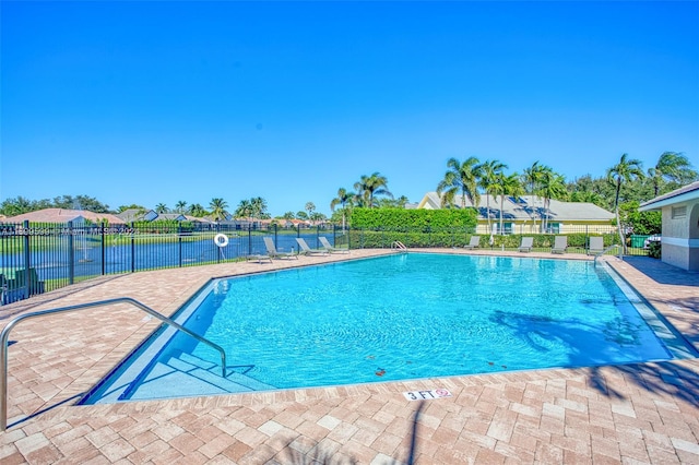 view of swimming pool featuring a water view and a patio