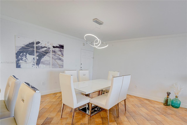 dining room with hardwood / wood-style floors and crown molding