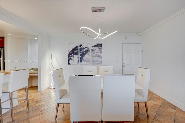 dining area featuring hardwood / wood-style floors, a chandelier, and ornamental molding