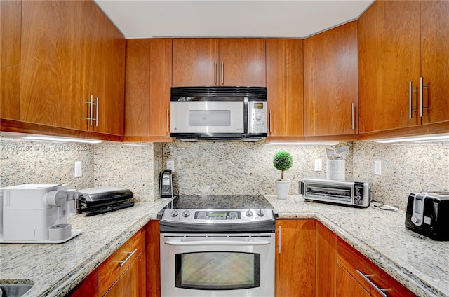 kitchen with tasteful backsplash, light stone countertops, and stainless steel appliances