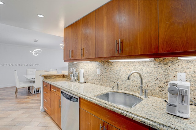 kitchen featuring decorative backsplash, light stone counters, dishwasher, and sink