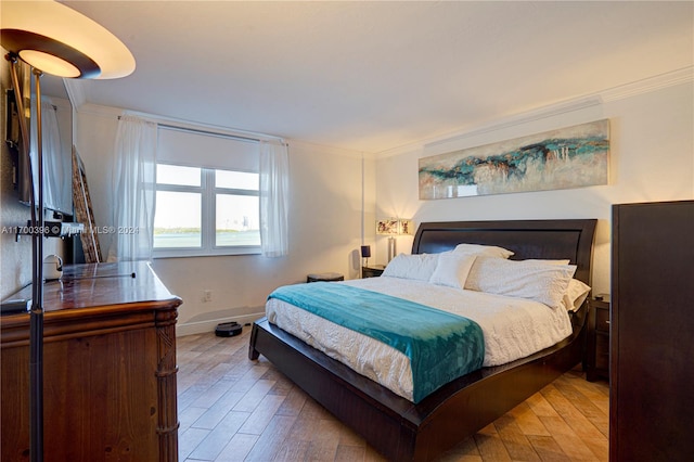 bedroom with wood-type flooring and ornamental molding