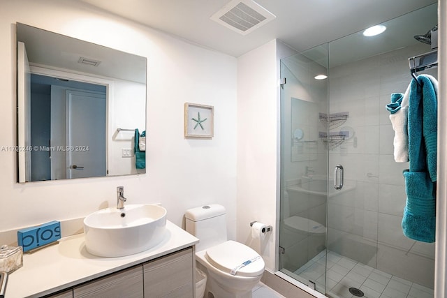 bathroom with vanity, an enclosed shower, and toilet