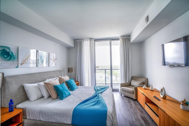 bedroom featuring dark hardwood / wood-style flooring and a wall of windows