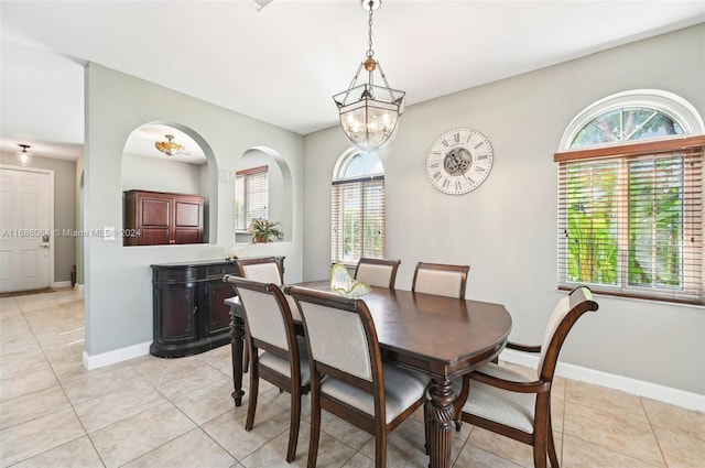 dining room featuring a notable chandelier and light tile patterned flooring