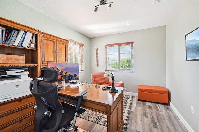 office space featuring a textured ceiling and light wood-type flooring