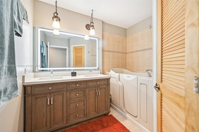 bathroom with tile patterned floors, a bathing tub, vanity, and tile walls