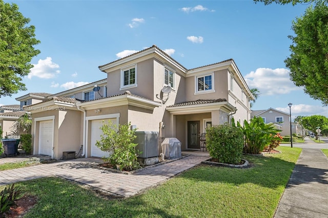 view of front of property featuring a garage, central AC, and a front lawn