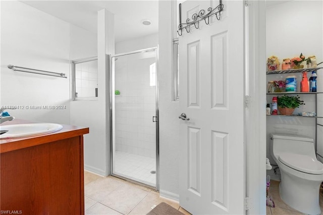 bathroom featuring tile patterned flooring, vanity, toilet, and a shower with shower door