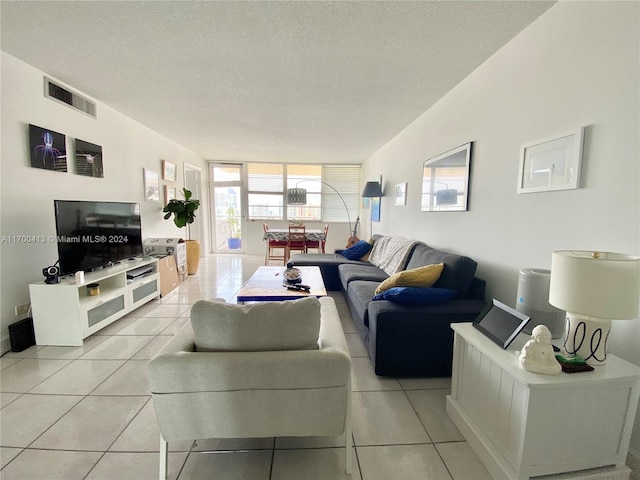 tiled living room featuring a textured ceiling