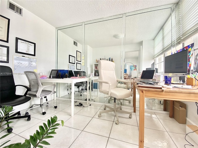 office area featuring tile patterned flooring and a textured ceiling