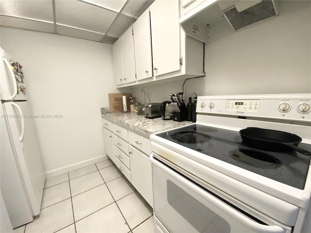 kitchen featuring light tile patterned floors, white appliances, white cabinetry, and range hood