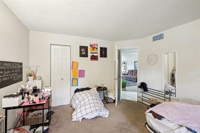 bedroom featuring a textured ceiling, carpet floors, and a closet