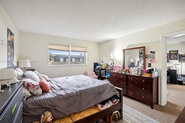 bedroom featuring a textured ceiling and light carpet