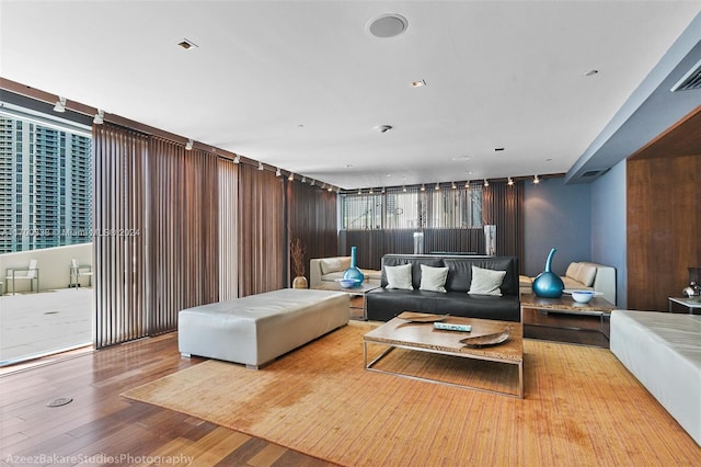 living room with light hardwood / wood-style floors and wood walls