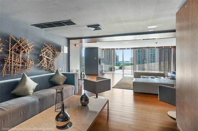 living room featuring floor to ceiling windows and light hardwood / wood-style floors