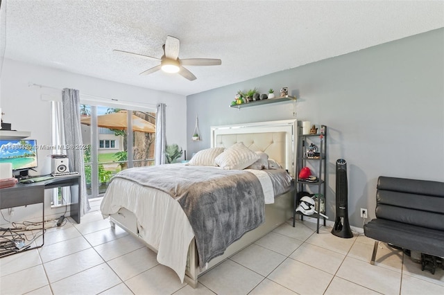 bedroom with ceiling fan, light tile patterned floors, and a textured ceiling