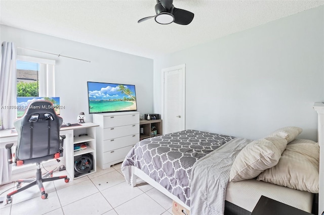 tiled bedroom featuring ceiling fan and a textured ceiling