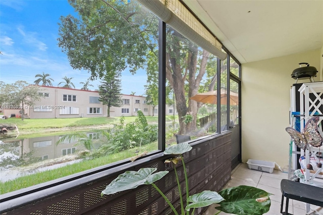 sunroom / solarium with a water view and a healthy amount of sunlight