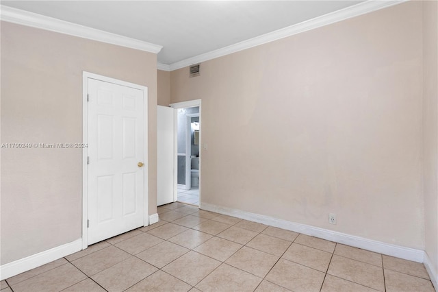 unfurnished room with light tile patterned floors and crown molding