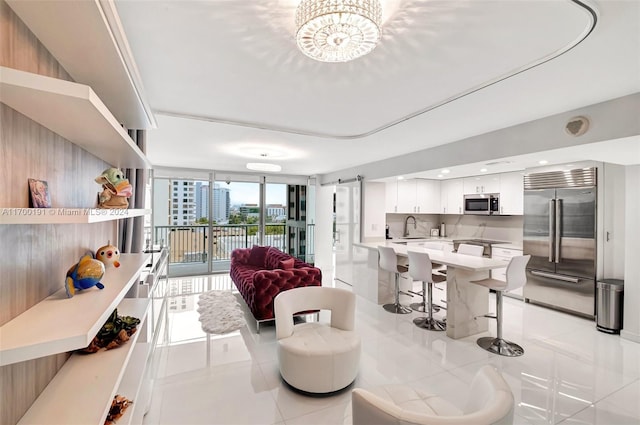 tiled living room featuring a wall of windows, sink, and an inviting chandelier