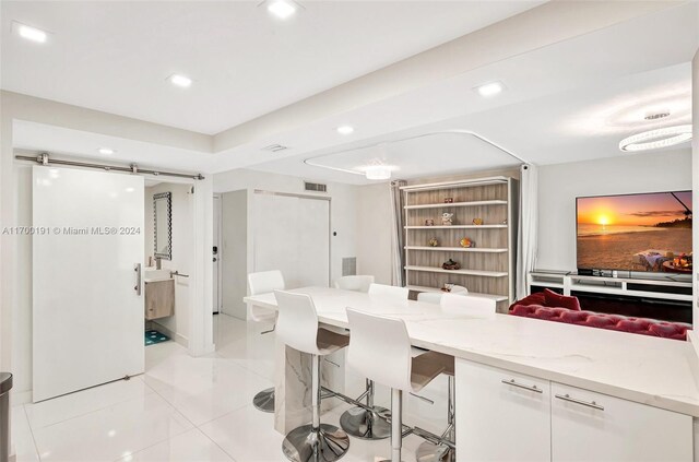 dining space with light tile patterned floors and a barn door