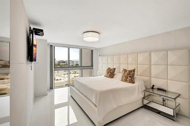 bedroom featuring light tile patterned floors and a wall of windows