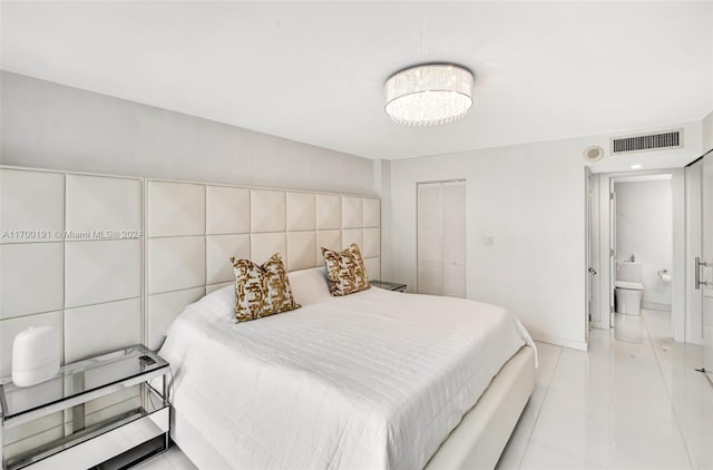 bedroom with light tile patterned flooring and ensuite bath