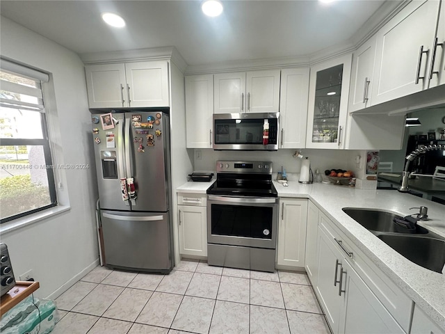 kitchen featuring light tile patterned floors, white cabinetry, sink, and appliances with stainless steel finishes