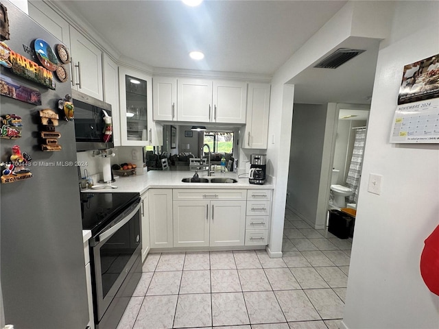 kitchen with white cabinets, light tile patterned flooring, sink, and appliances with stainless steel finishes