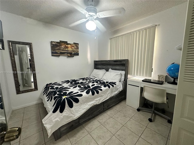 tiled bedroom with ceiling fan and a textured ceiling